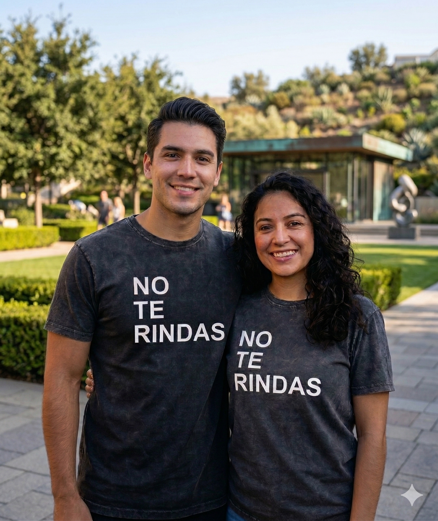 Pareja con playeras negras de Alex Ubago diseño No Te Rindas mercancía oficial HipMerch