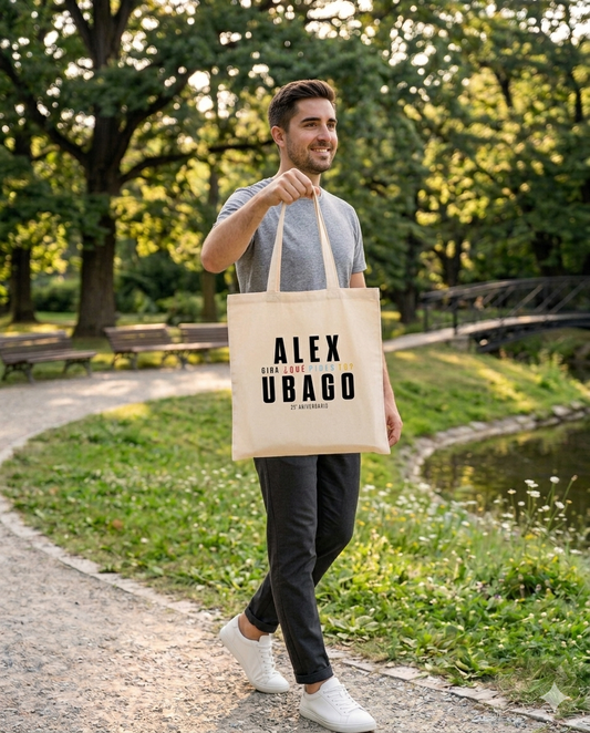 Hombre usando la bolsa de tela oficial del 25 aniversario de Alex Ubago en un entorno urbano cálido.