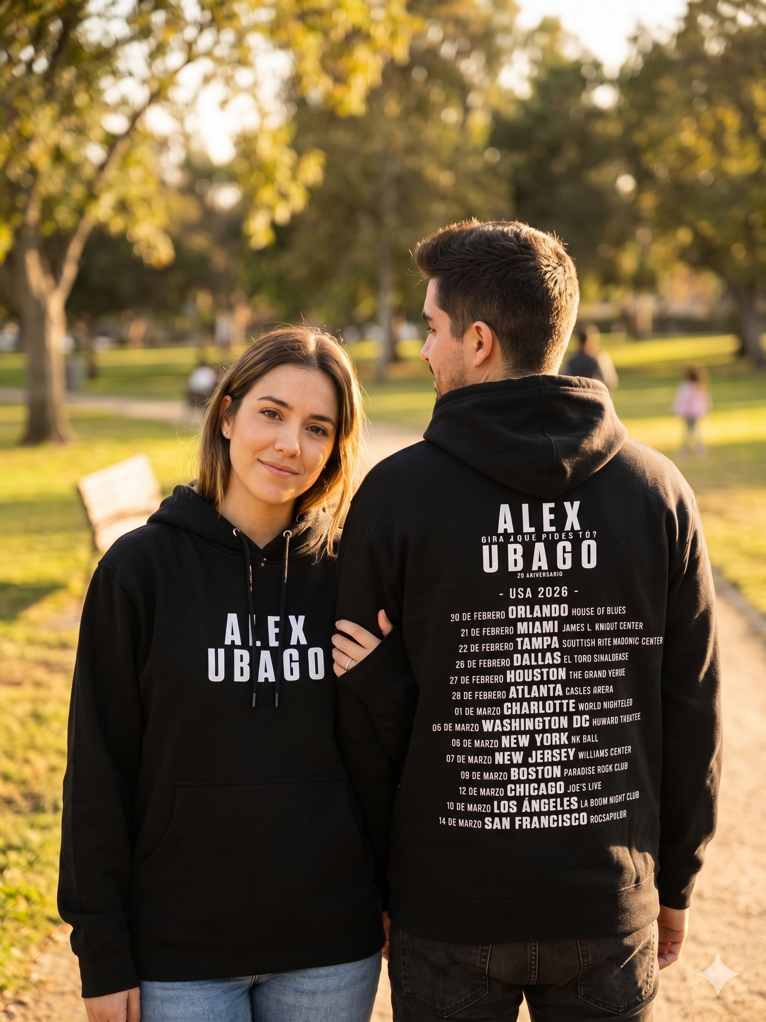 Pareja modelando la sudadera oficial de Alex Ubago en la calle; uno muestra el diseño frontal y el otro la lista de ciudades de la gira por USA en la espalda.