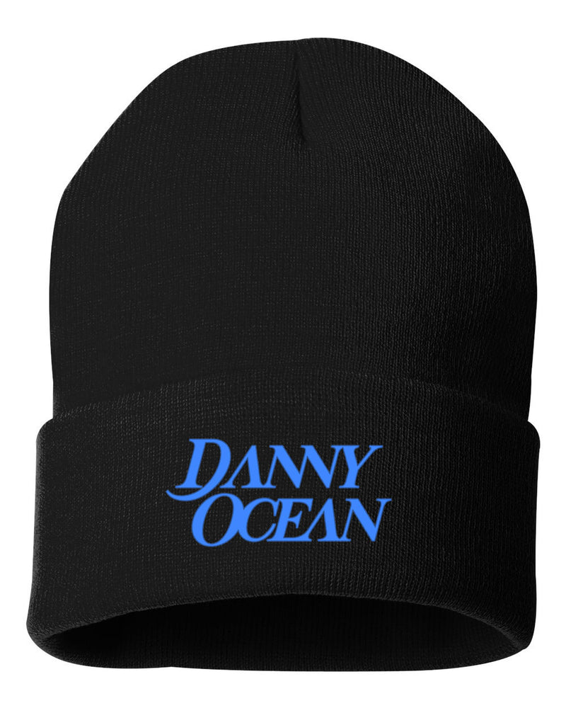 Maqueta digital del gorro tejido tipo beanie negro con el nombre de Danny Ocean bordado en hilo azul vibrante, mercancía oficial de alta calidad.