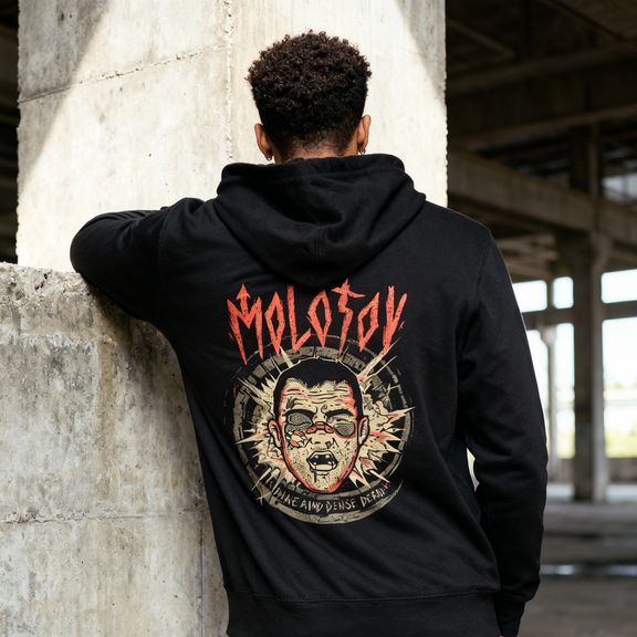 Fotografía en plano medio (medium shot) de un modelo posando de espaldas apoyado en una columna de concreto, exhibiendo el arte oficial de la sudadera de Molotov.