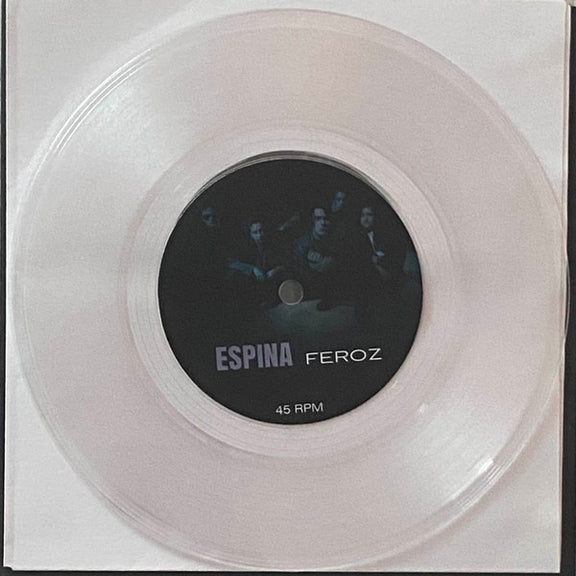 Vista del disco de vinilo físico de 7 pulgadas en formato transparente (clear vinyl) mostrando la etiqueta central negra del Lado A.