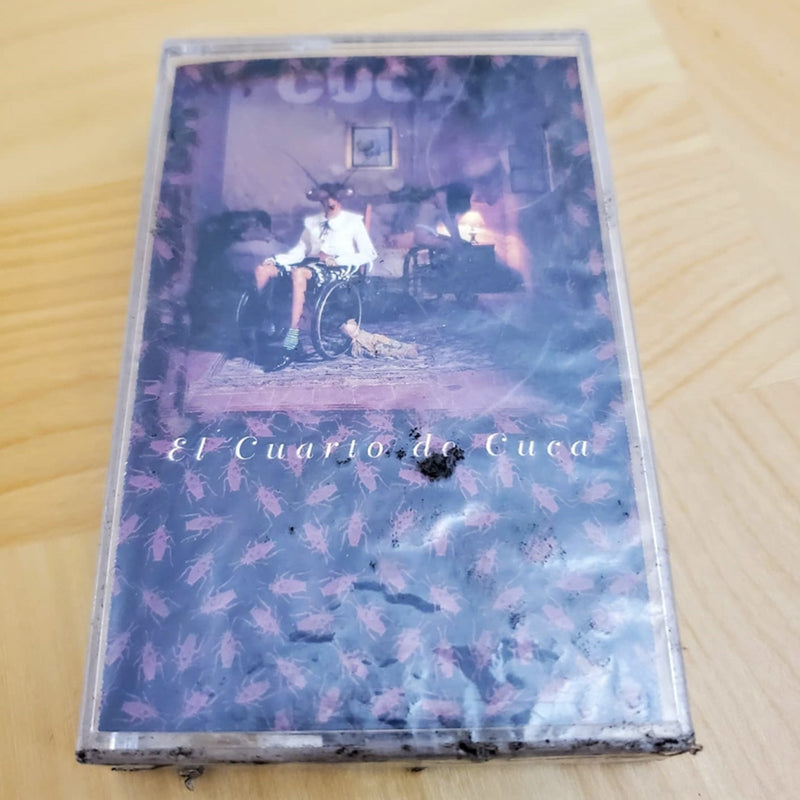 Fotografía del cassette original El Cuarto De Cuca de la banda Cuca, mostrando la portada icónica y el cuerpo plástico del cartucho.