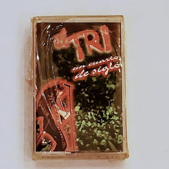 Fotografía en primer plano del cassette original de El Tri titulado Un Cuarto De Siglo Vol. 1, mostrando el arte de portada vintage de aniversario y los detalles del cartucho.
