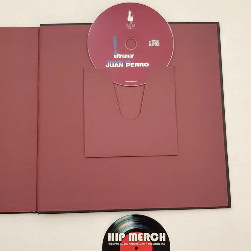Fotografía del disco compacto oficial de Juan Perro colocado sobre su ranura del empaque rígido interior del libro de colección.