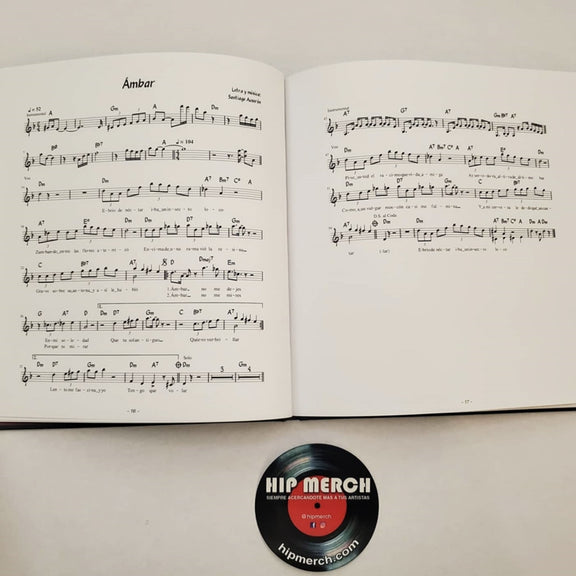 Fotografía de las páginas abiertas del libro de Juan Perro que muestra las partituras musicales de las canciones incluidas en el álbum.