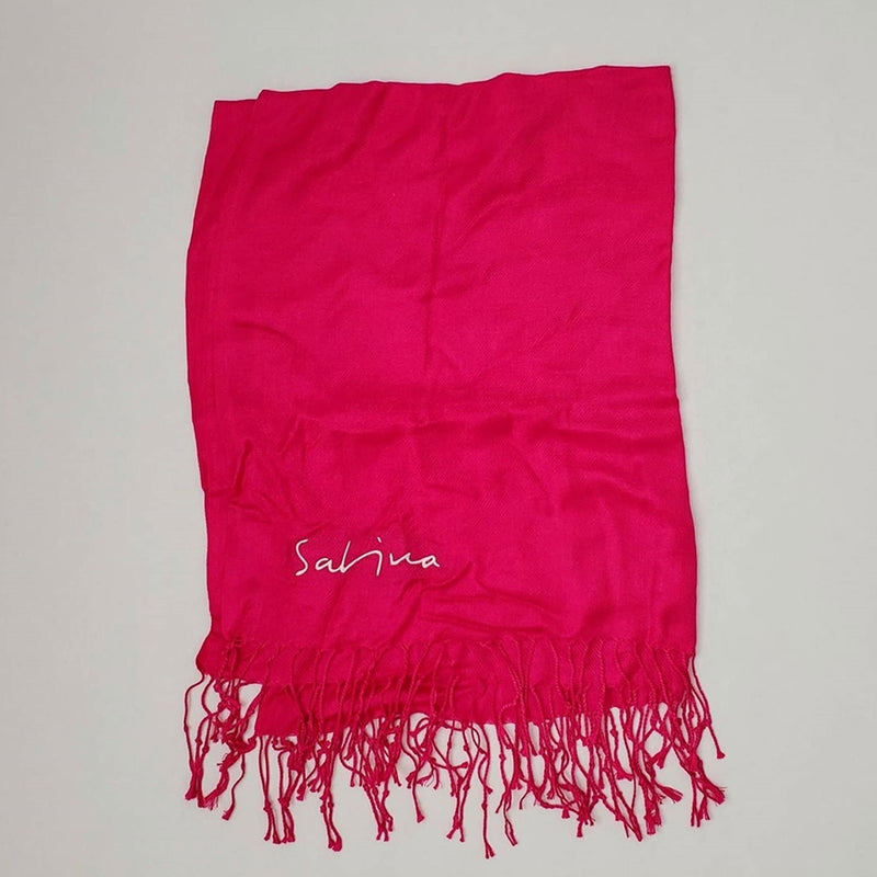 Maqueta digital que muestra la pashmina oficial tipo chal de Joaquín Sabina desplegada, detallando la caída ligera de la tela, los acabados de los bordes y el gráfico impreso de colección.