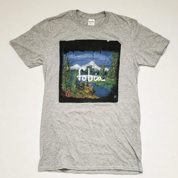 Fotografía de la vista frontal de la playera gris oficial de Fobia, mostrando el diseño de cuello redondo y el logotipo de la banda estampado en el pecho.