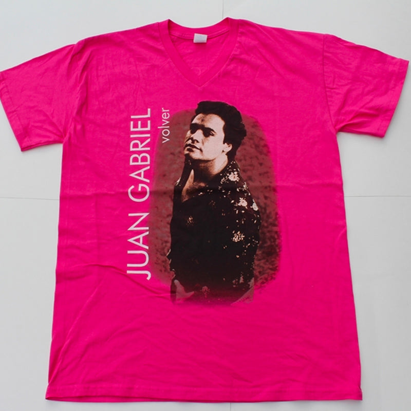 Fotografía de catálogo de la playera rosa oficial de Juan Gabriel con cuello en V, mostrando el diseño gráfico vintage estampado en el centro.