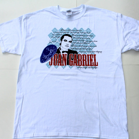 Fotografía de catálogo de la playera blanca oficial de Juan Gabriel, mostrando el diseño gráfico de colección centrado en el pecho.