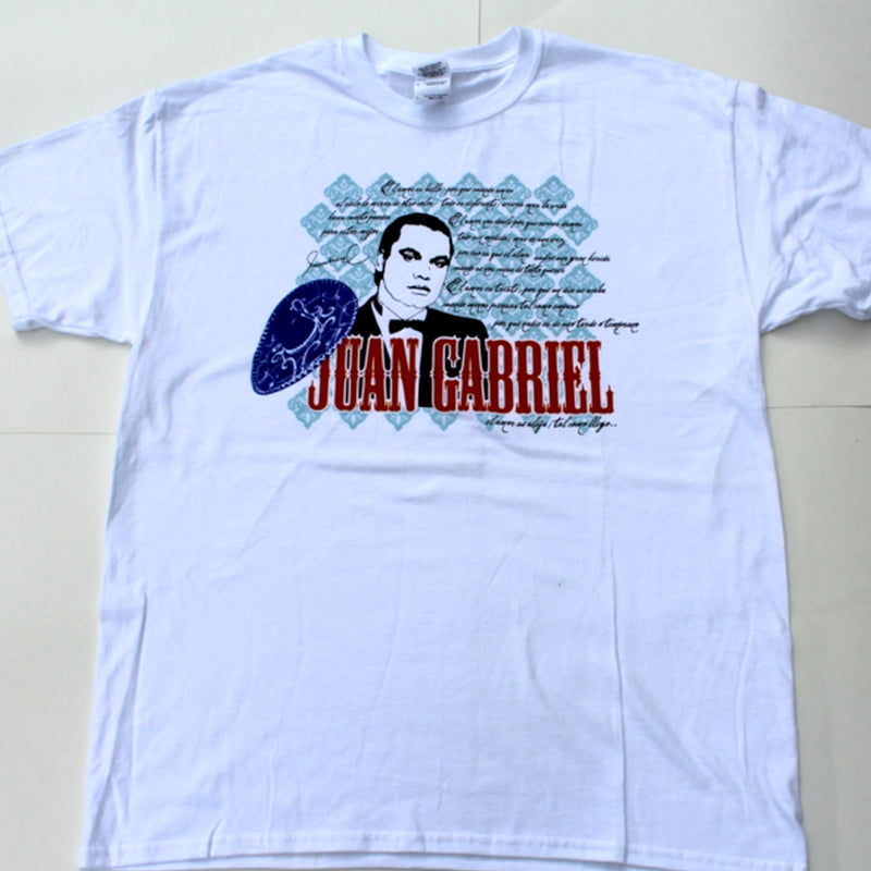 Fotografía de catálogo de la playera blanca oficial de Juan Gabriel, mostrando el diseño gráfico de colección centrado en el pecho.