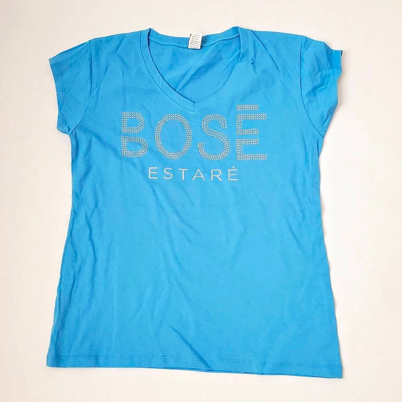 Fotografía de catálogo de la playera azul oficial de Miguel Bosé con corte para mujer, mostrando el diseño y ajuste del textil.