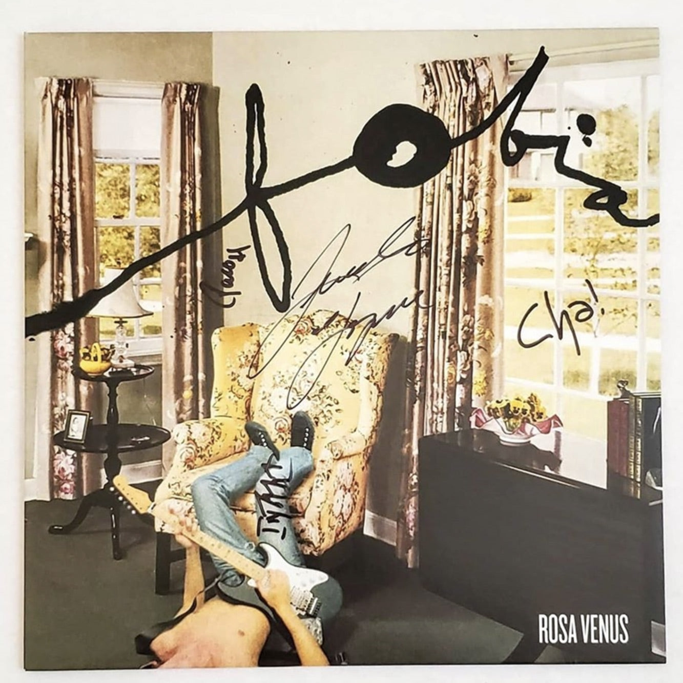 Fotografía de la portada oficial del álbum Rosa Venus de Fobia con las firmas auténticas hechas a mano por los integrantes sobre el diseño clásico de la sala.