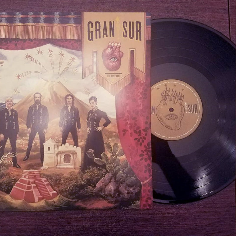 Fotografía de exhibición del disco de vinilo negro de Gran Sur asomando por un costado de la portada física del álbum Ay, Dolor.