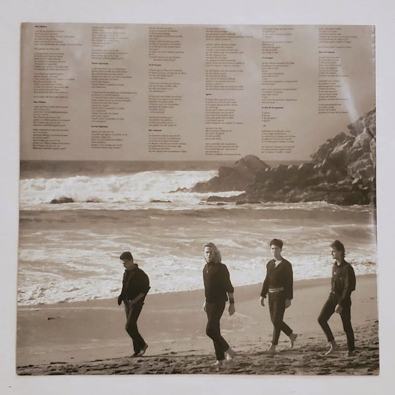 Fotografía de la contraportada del álbum El Mar No Cesa de Héroes del Silencio con los integrantes caminando por la playa y el listado de canciones impreso.