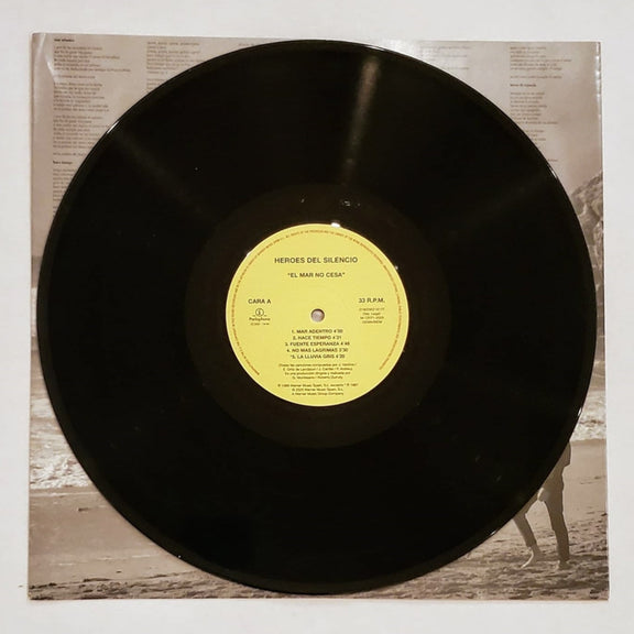 Fotografía del disco de vinilo negro de 180 gramos correspondiente al álbum El Mar No Cesa, destacando su etiqueta circular central en color amarillo.