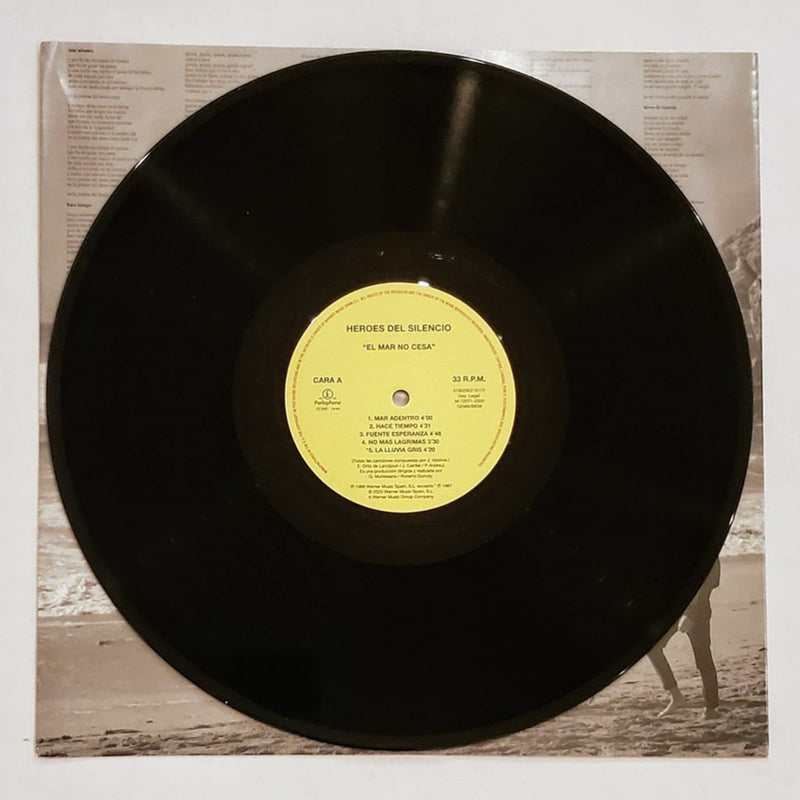 Fotografía del disco de vinilo negro de 180 gramos correspondiente al álbum El Mar No Cesa, destacando su etiqueta circular central en color amarillo.