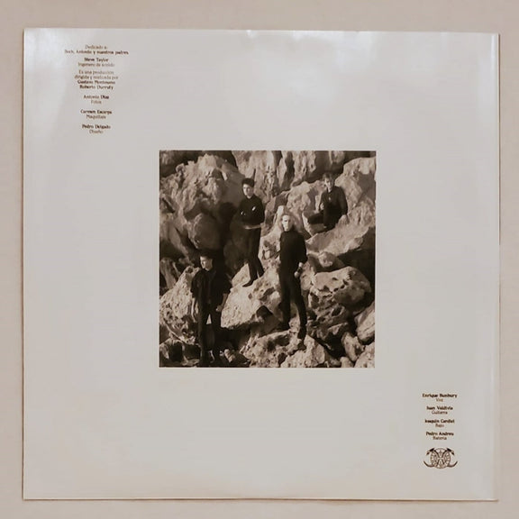 Fotografía de la funda protectora interior de papel blanco que muestra una fotografía cuadrada en blanco y negro de la banda en una zona rocosa.