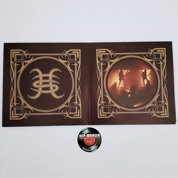 Fotografía de la sección derecha del empaque desplegable gatefold abierto que exhibe la ornamentación dorada que enmarca una toma de la banda actuando en el escenario.