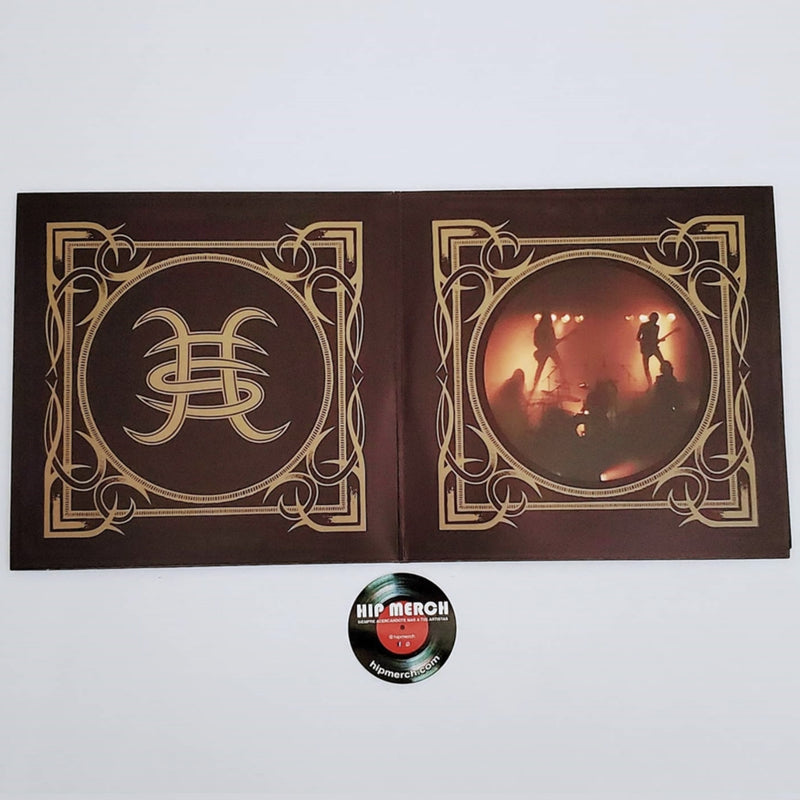 Fotografía de la sección derecha del empaque desplegable gatefold abierto que exhibe la ornamentación dorada que enmarca una toma de la banda actuando en el escenario.