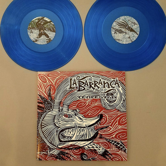 Fotografía de la portada oficial del álbum Tempestad de La Barranca acompañada por sus dos discos de vinilo traslúcidos de color azul de la edición limitada.
