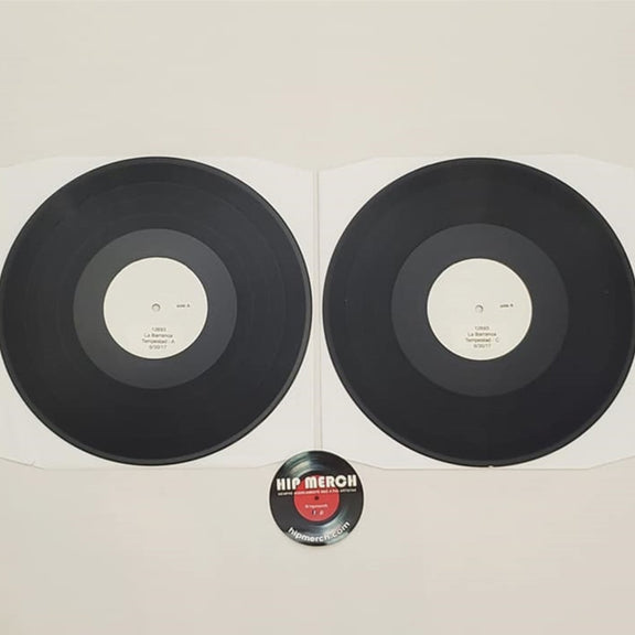 Fotografía de los dos discos de vinilo negros correspondientes a la edición de prueba Test Pressing del álbum Tempestad de La Barranca fuera de sus empaques.