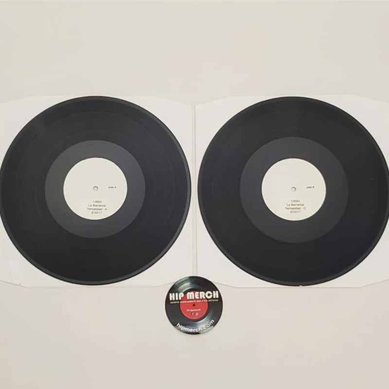 Fotografía de los dos discos de vinilo negros correspondientes a la edición de prueba Test Pressing del álbum Tempestad de La Barranca fuera de sus empaques.