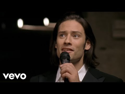 Video integrado que muestra material audiovisual promocional y tomas de exhibición detalladas de la playera oficial de Il Divo para las festividades.